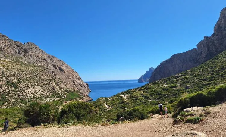 Excursionistas junto al mar en Cala Boquer